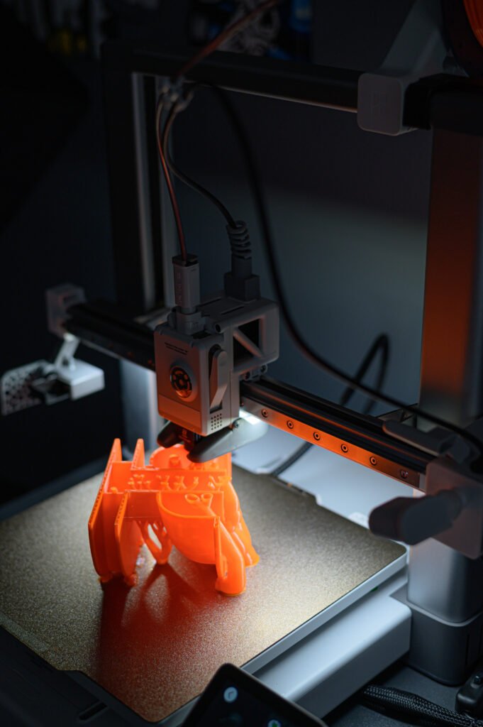 3D Printer Creating Vibrant Orange Prototype Model